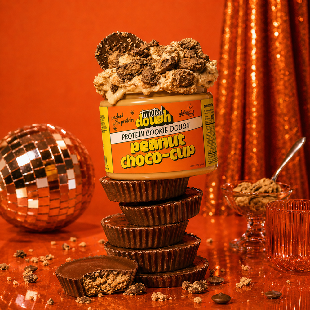 Twisted Dough Protein Cookie Dough Peanut Choco-Cup on a red background with chocolate cups and cookie dough.