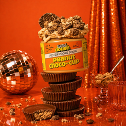 Twisted Dough Peanut Choco-Cup protein cookie dough jar with a sandwich on a pink background